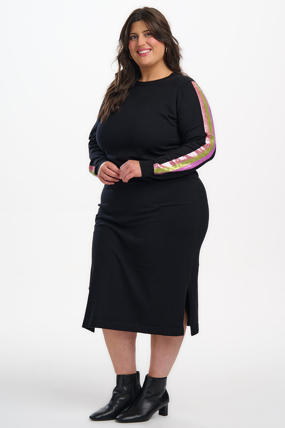 Woman wearing a black dress with colorful sleeves on a white background