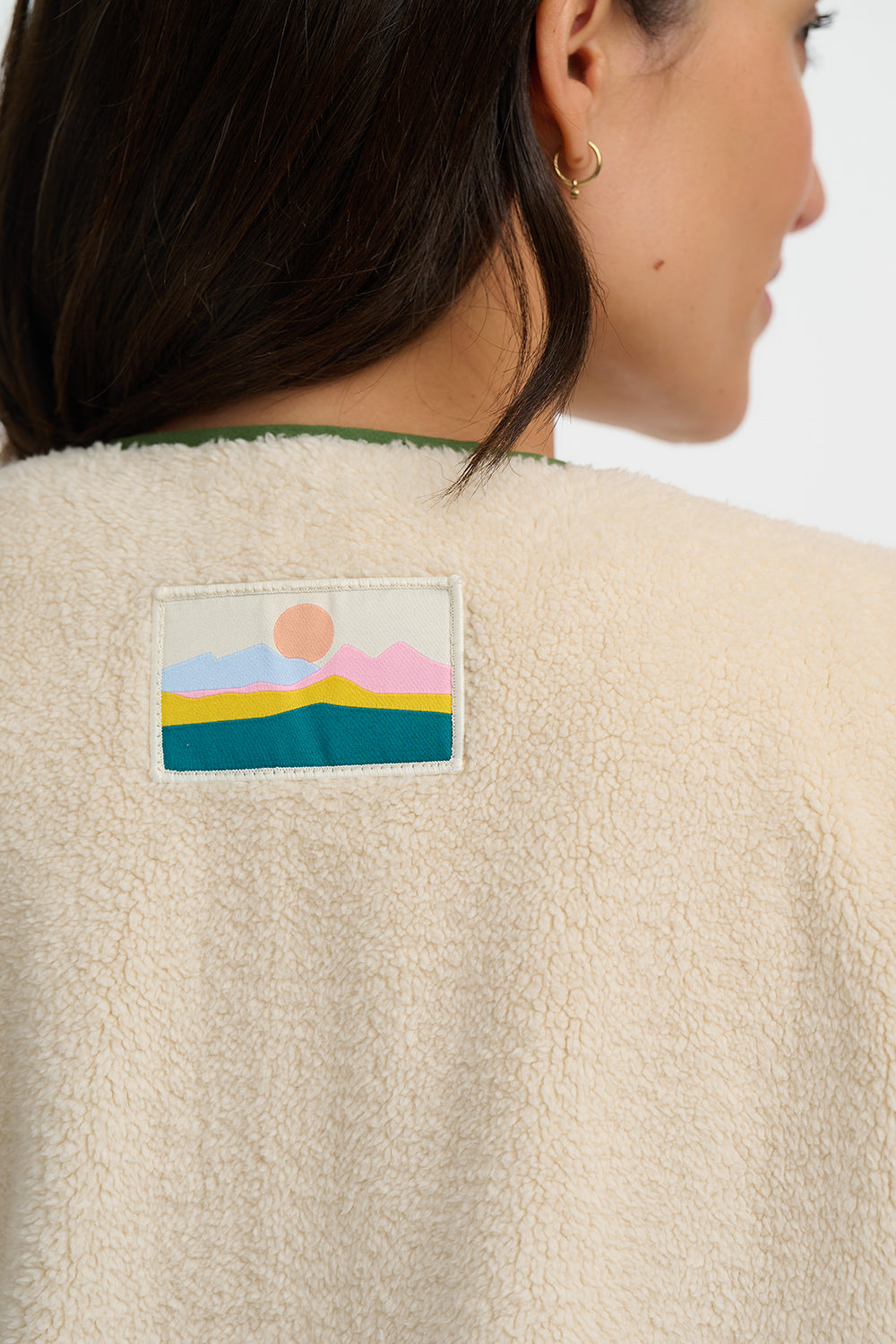 Beige fleece jacket with a colorful patch on the back