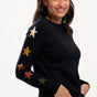 model wearing a black jumper with stars on the sleeves 
