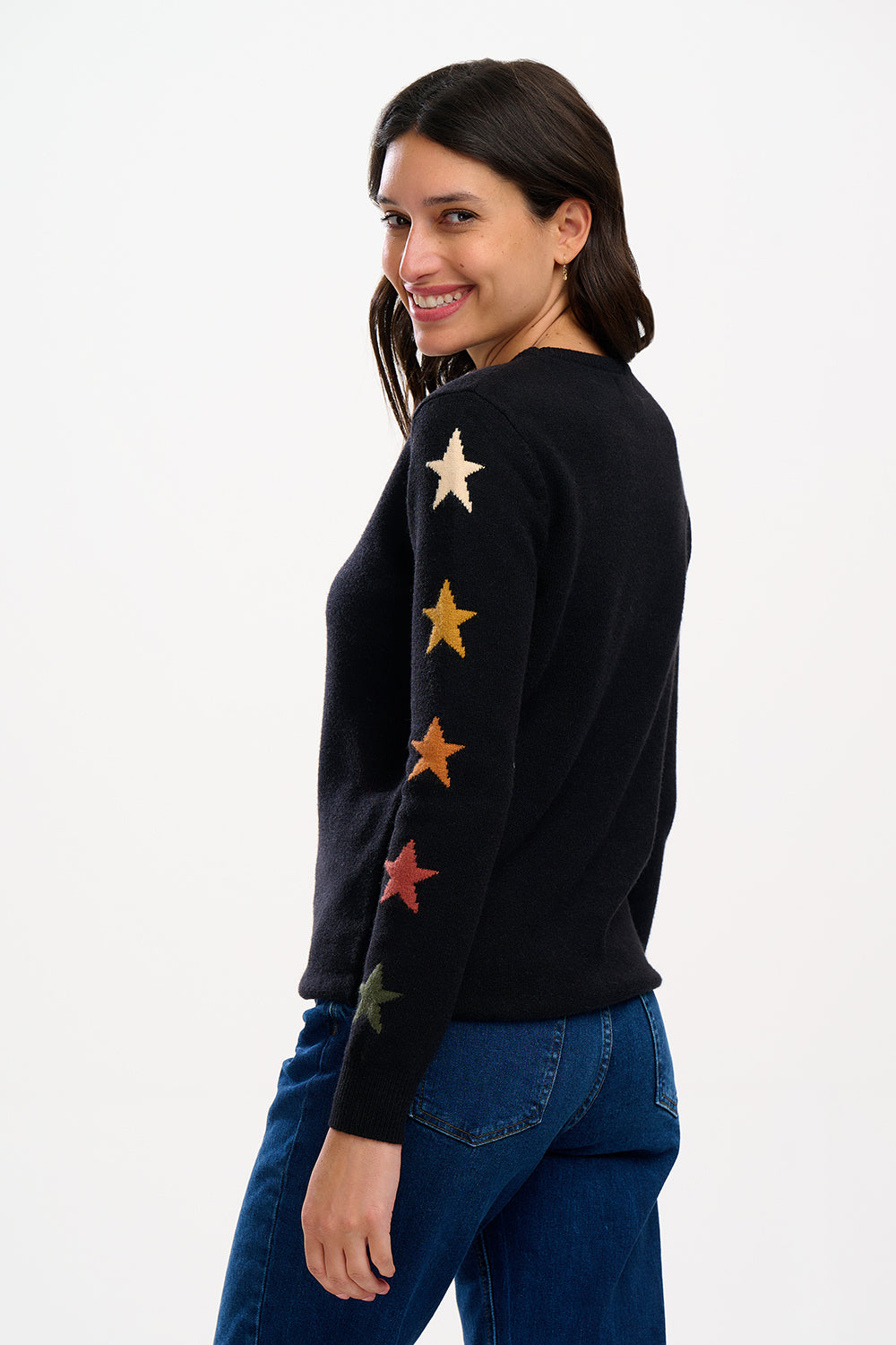 model wearing a black jumper with stars on the sleeves 