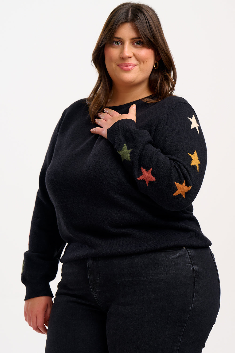 model wearing a black jumper with stars on the sleeves 