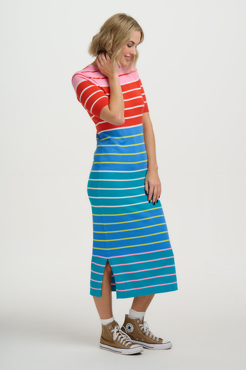 Person wearing a red and white striped top with a blue and yellow striped skirt on a white background