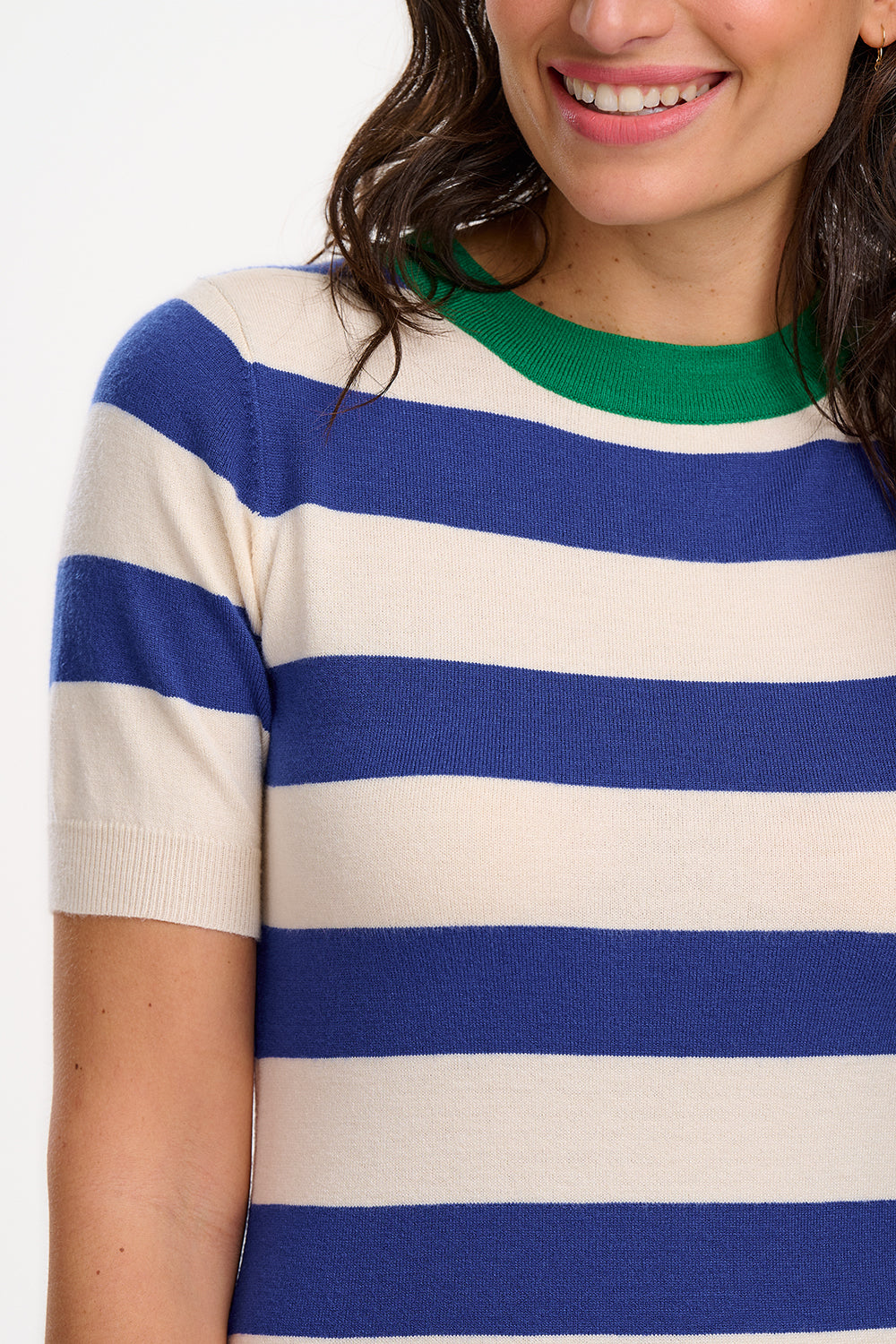A model wearing a short-sleeved blue and white striped midi knit dress with a contrasting green neckline.