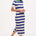 A model wearing a short-sleeved blue and white striped midi knit dress with a contrasting green neckline.