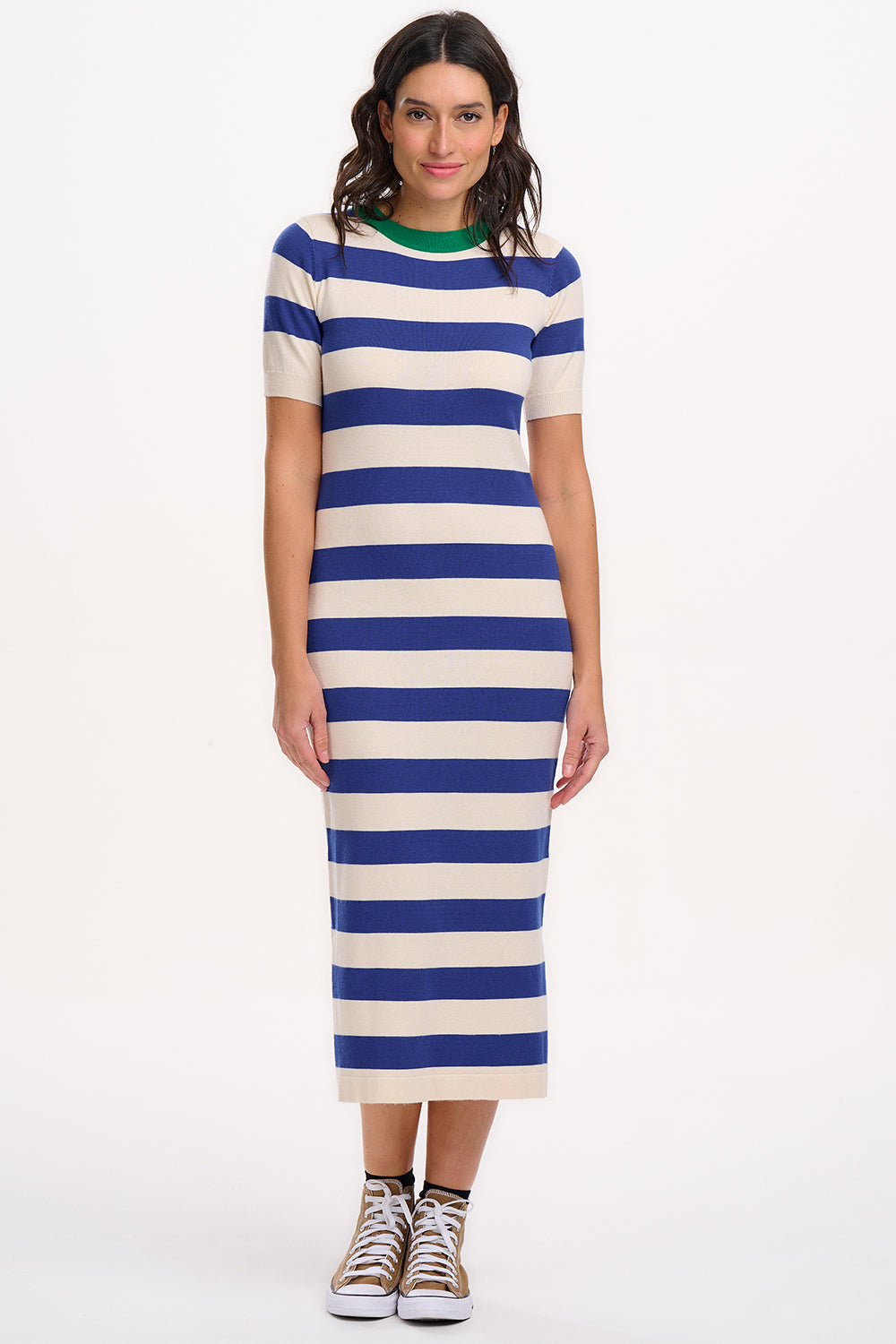 A model wearing a short-sleeved blue and white striped midi knit dress with a contrasting green neckline.
