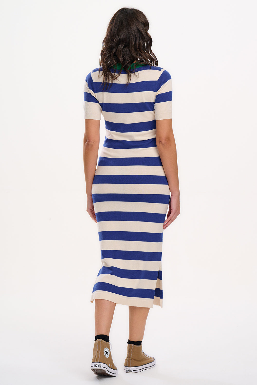 A model wearing a short-sleeved blue and white striped midi knit dress with a contrasting green neckline.