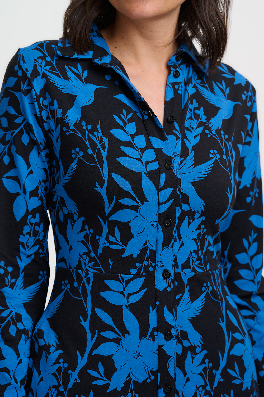 Close-up of a black shirt with blue floral and bird pattern