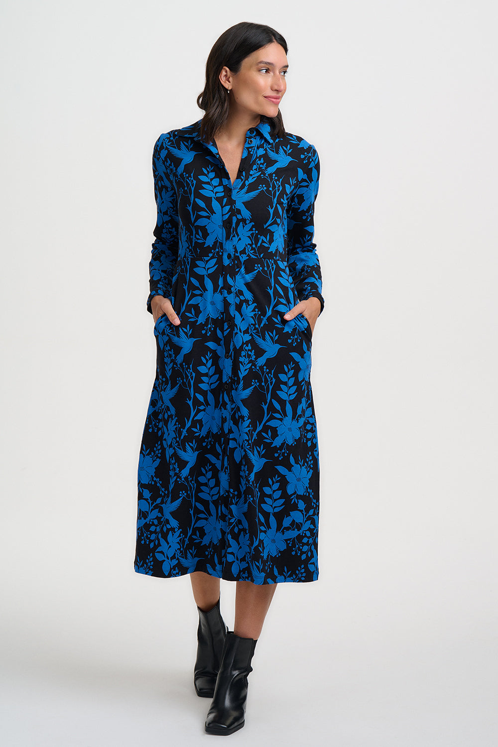 Woman wearing a blue and black patterned dress on a white background