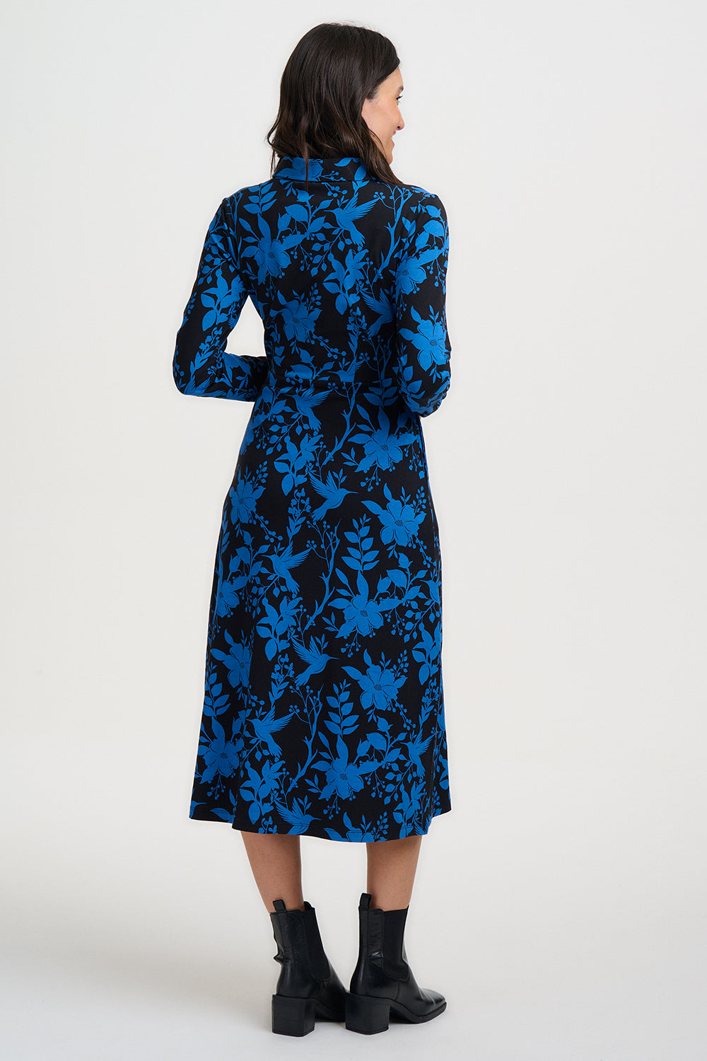 Woman wearing a blue and black floral patterned dress on a white background