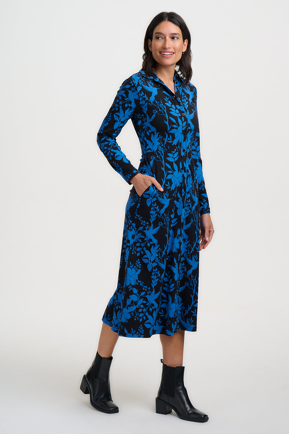 Woman wearing a blue and black patterned dress on a white background