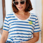 Woman wearing a blue and white striped shirt with sunglasses indoors.
