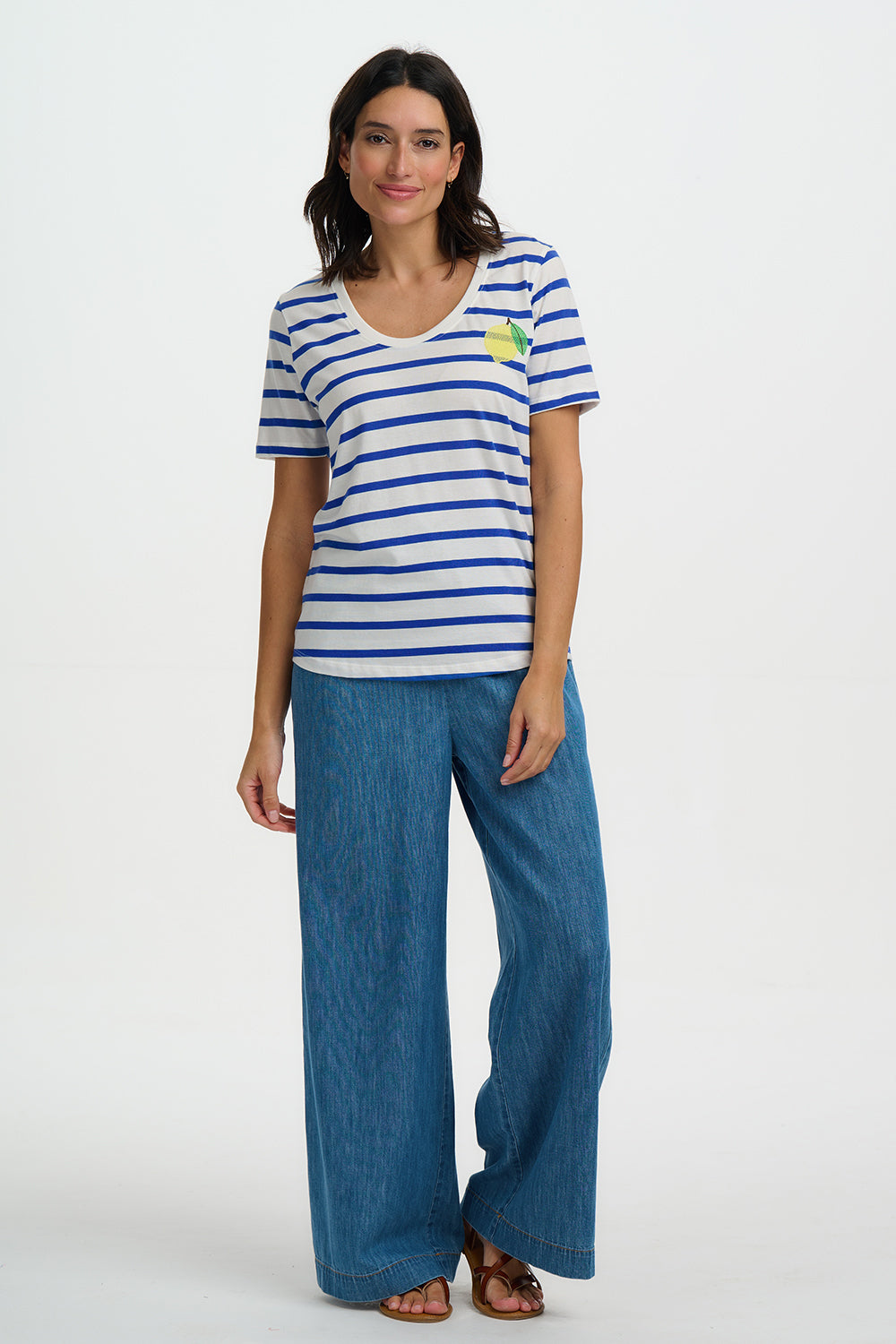 Woman wearing a striped shirt and blue pants on a white background