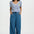 Woman wearing a striped shirt and wide-leg jeans on a white background