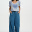 Woman wearing a striped shirt and wide-leg jeans on a white background