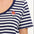 A woman wearing a striped scoop neck t-shirt in white and navy colors with a small floral design on the chest