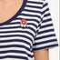 A woman wearing a striped scoop neck t-shirt in white and navy colors with a small floral design on the chest