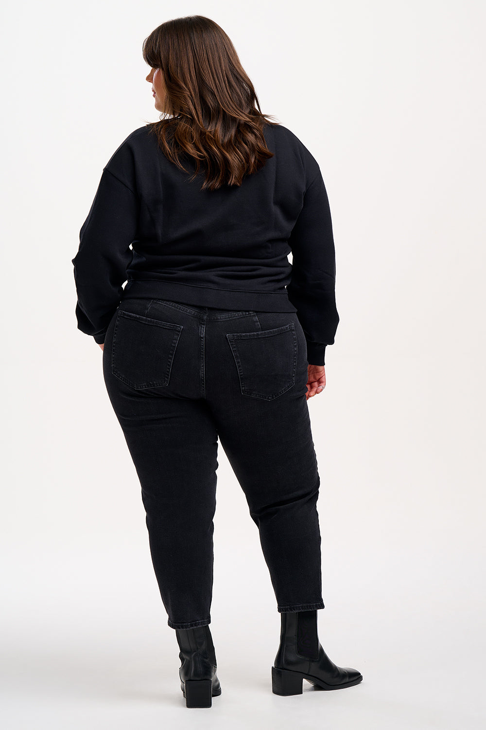 A person wearing a black sweatshirt with a sequin lightning bolt design on the front