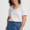Woman wearing a colorful striped shirt and blue pants against a white background