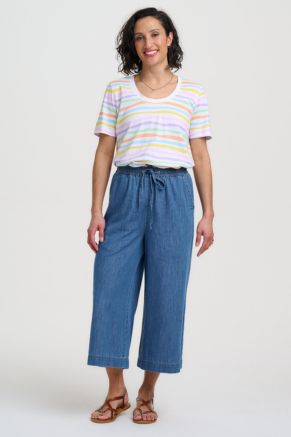 Woman wearing a striped shirt and blue pants on a white background
