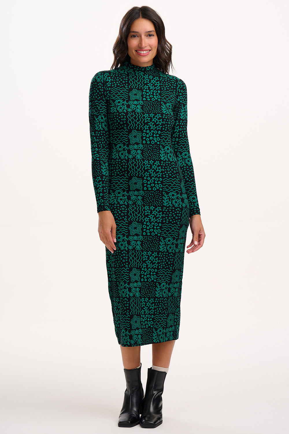 Woman wearing a green patterned dress on a white background