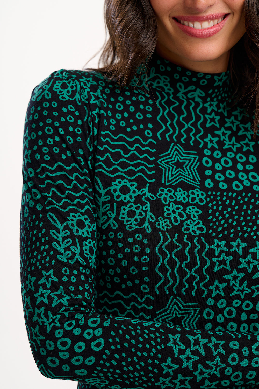 Person wearing a dark green patterned long-sleeve shirt with a white background