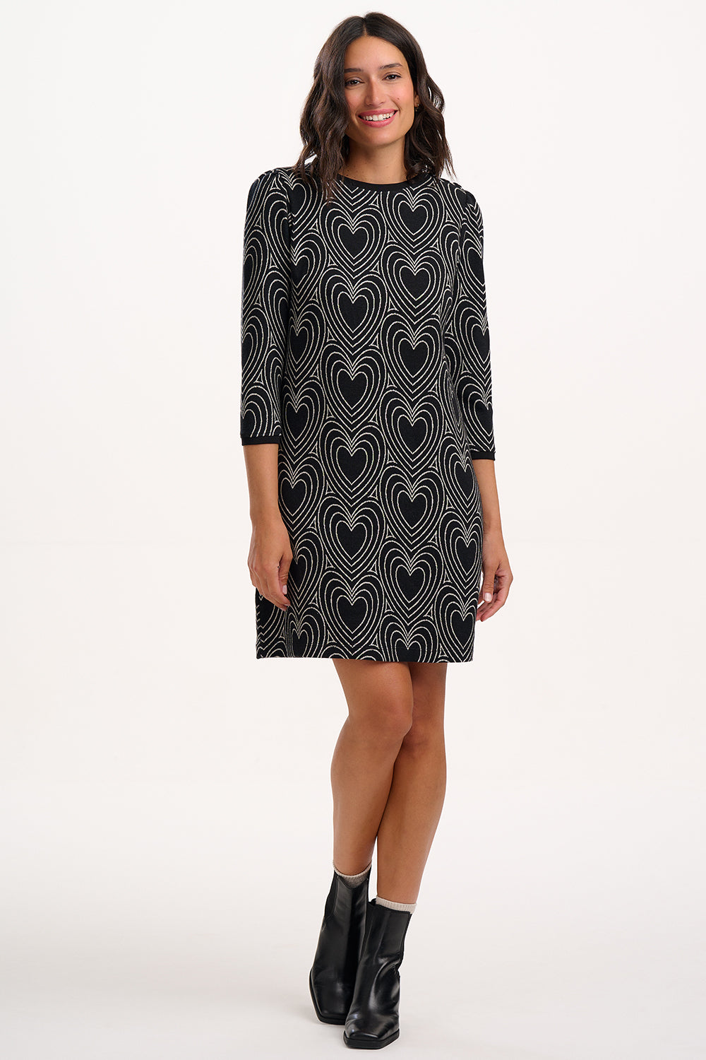 Woman wearing a black dress with heart pattern on a white background