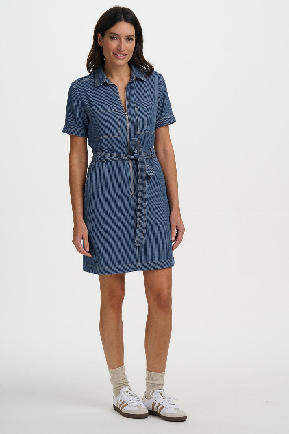 Woman wearing a blue denim dress on a white background