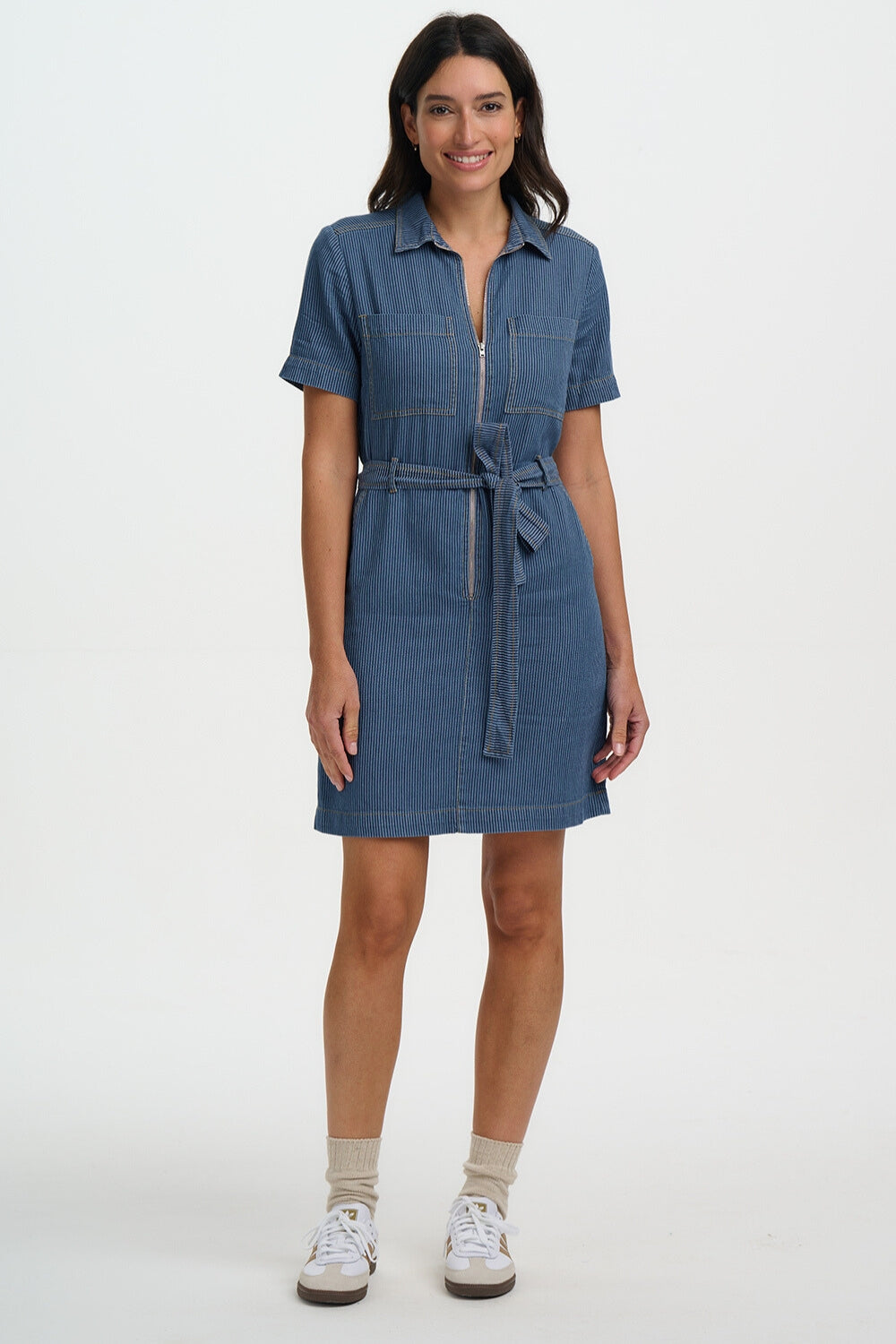 Woman wearing a blue denim dress on a white background
