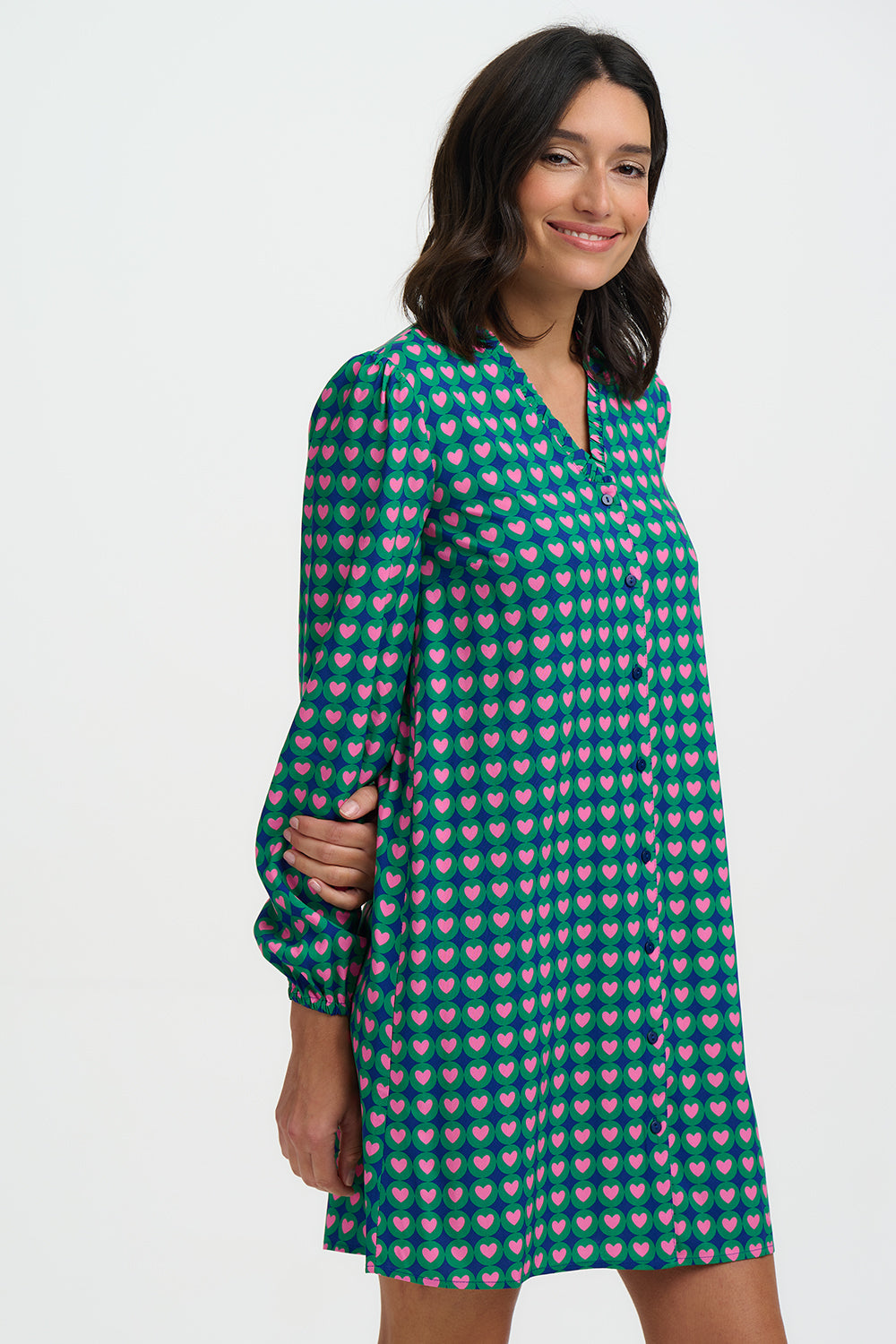 Woman wearing a green patterned dress on a white background