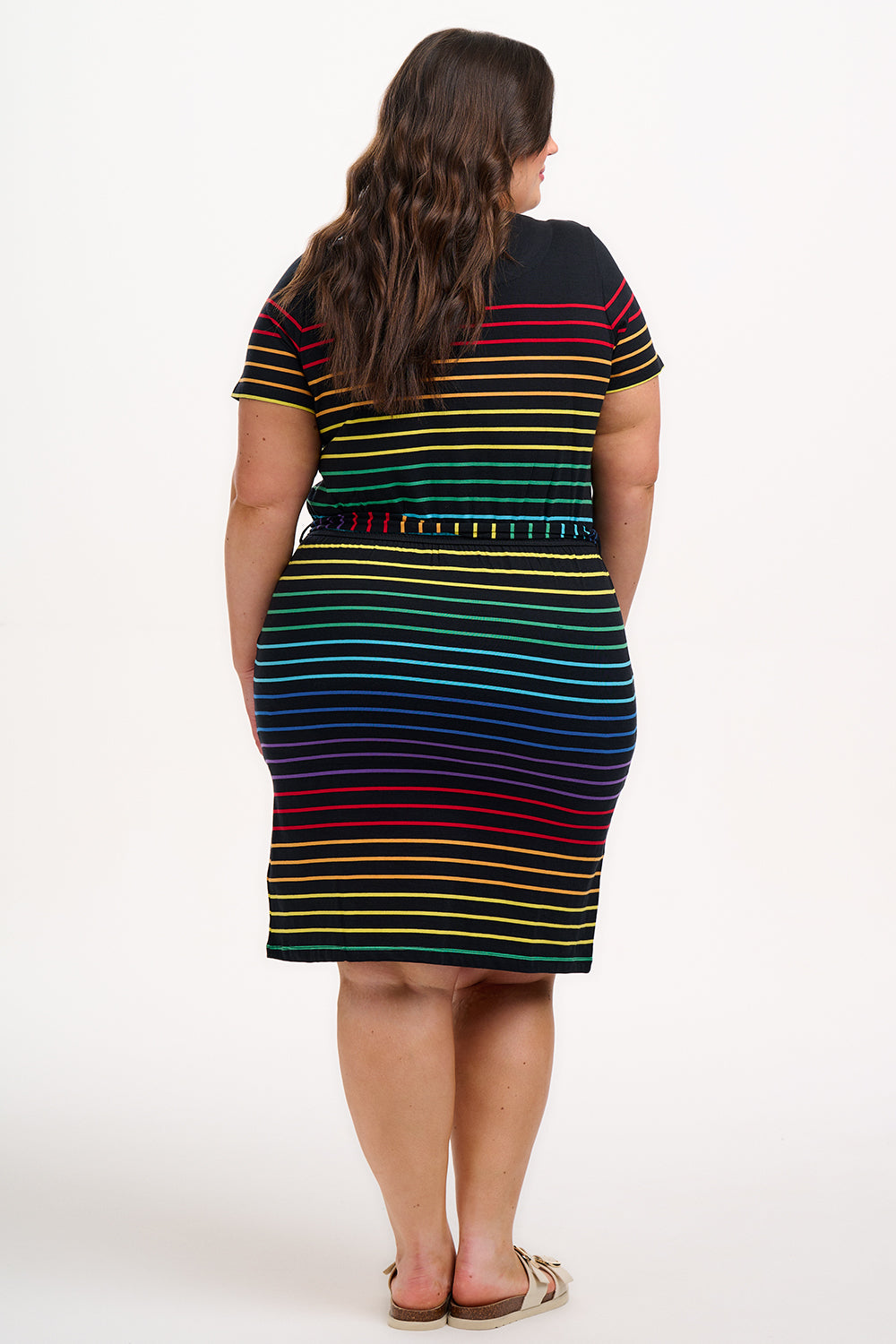 A model wearing a short-sleeved black mini dress with a colorful striped pattern and pockets