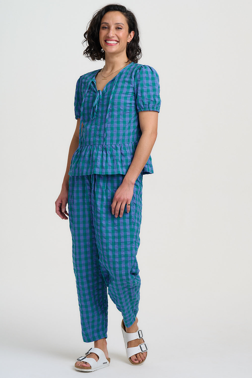 Woman wearing a blue checkered outfit on a white background