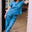 Woman in a blue outfit standing in a doorway.