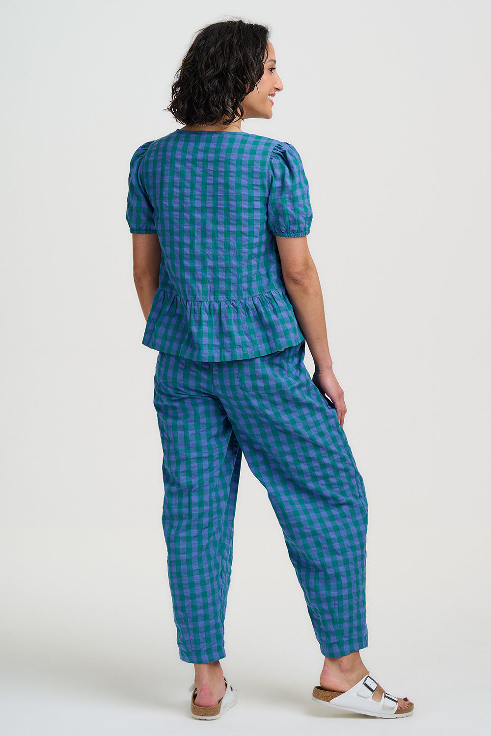 Woman wearing a blue checkered outfit on a white background
