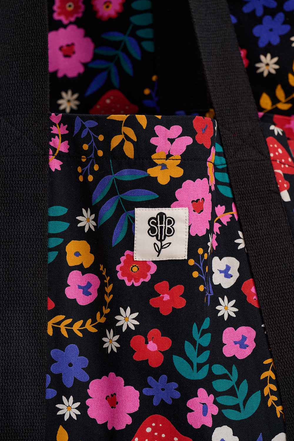 Floral-patterned bag with a visible brand logo on a black background