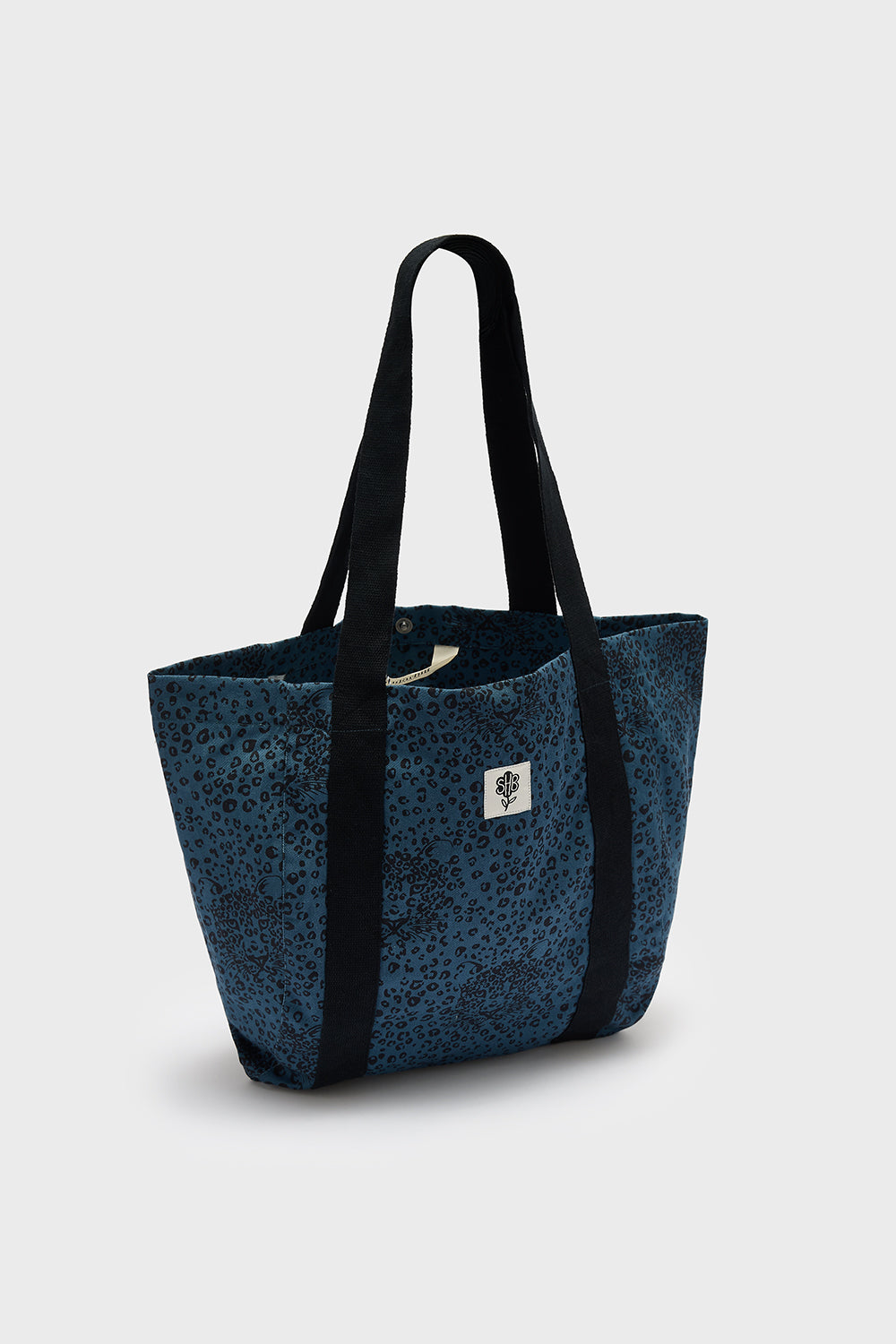 Blue tote bag with black straps on a light gray background