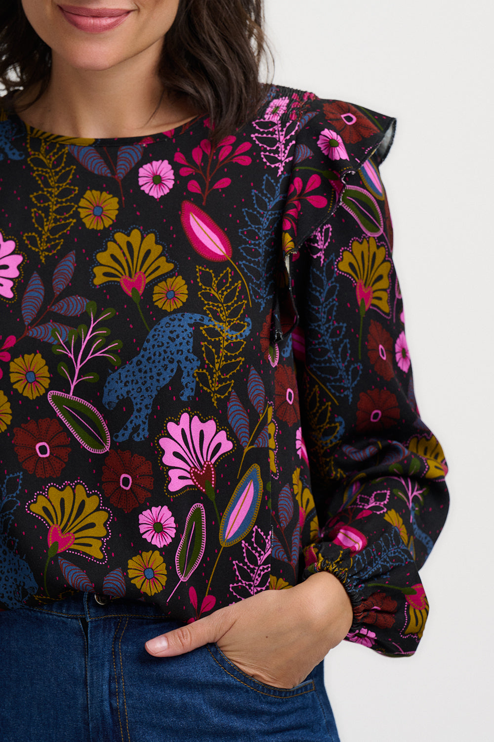 Woman wearing a colorful floral blouse with a white background