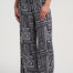 Black and white geometric patterned pants worn by a person on a white background