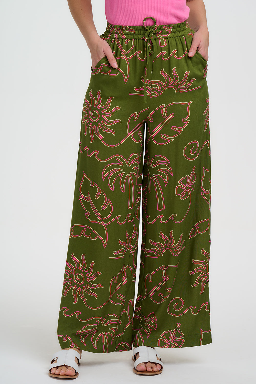 Green patterned pants worn by a person on a white background