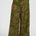 Green patterned pants worn by a person on a white background