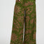 Green patterned pants worn by a person on a white background