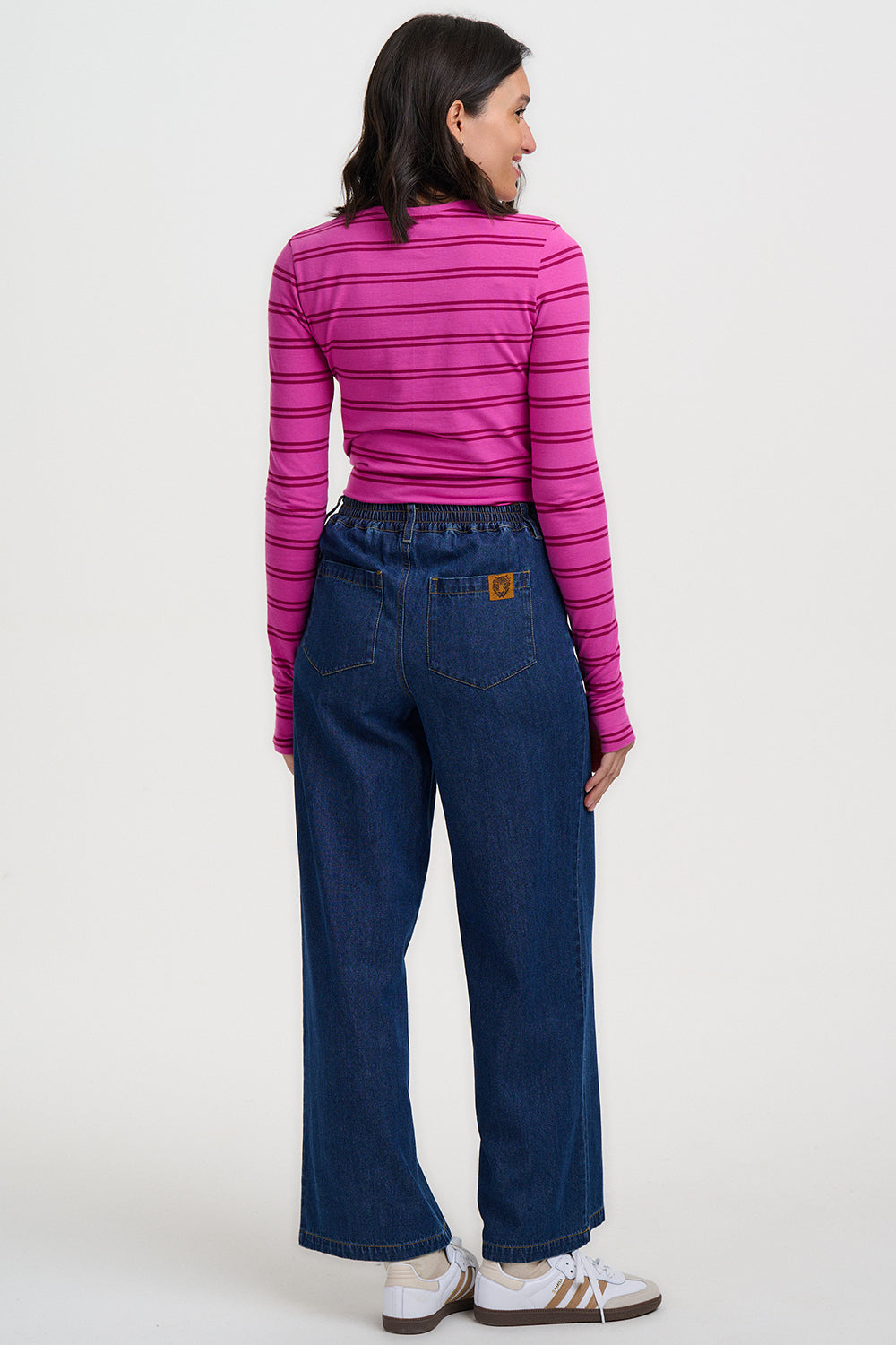 Person wearing a pink striped shirt and blue jeans on a white background
