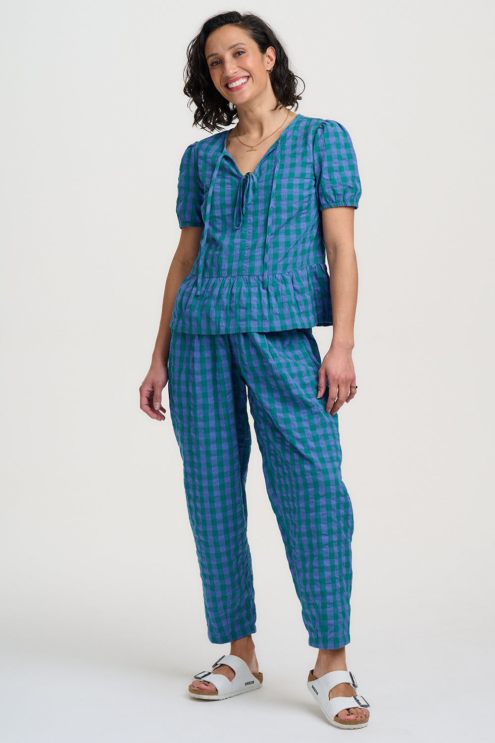 Woman wearing a blue checkered outfit on a white background