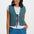 Woman wearing a patterned vest over a white shirt and blue pants on a white background