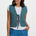 Woman wearing a patterned vest over a white shirt and blue pants on a white background