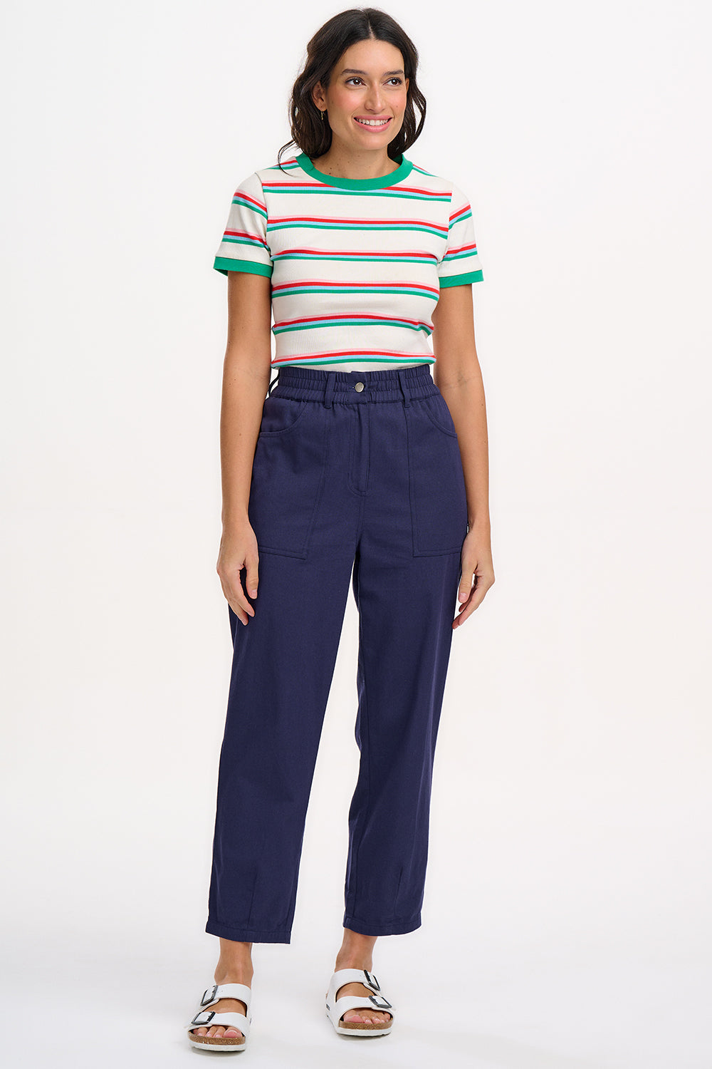 A woman wearing an off-white fitted t-shirt with retro stripes in red and green colors, and contrast cuffs.