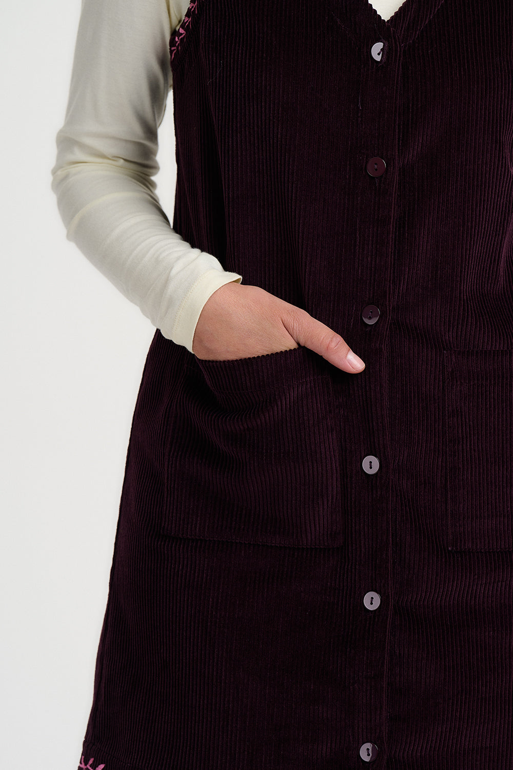 Dark brown corduroy dress with buttons on a white background