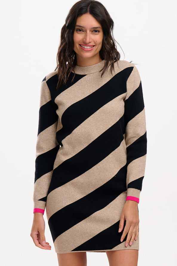 A woman wearing a beige and black diagonal striped knit dress with long sleeves and a crew neck.
