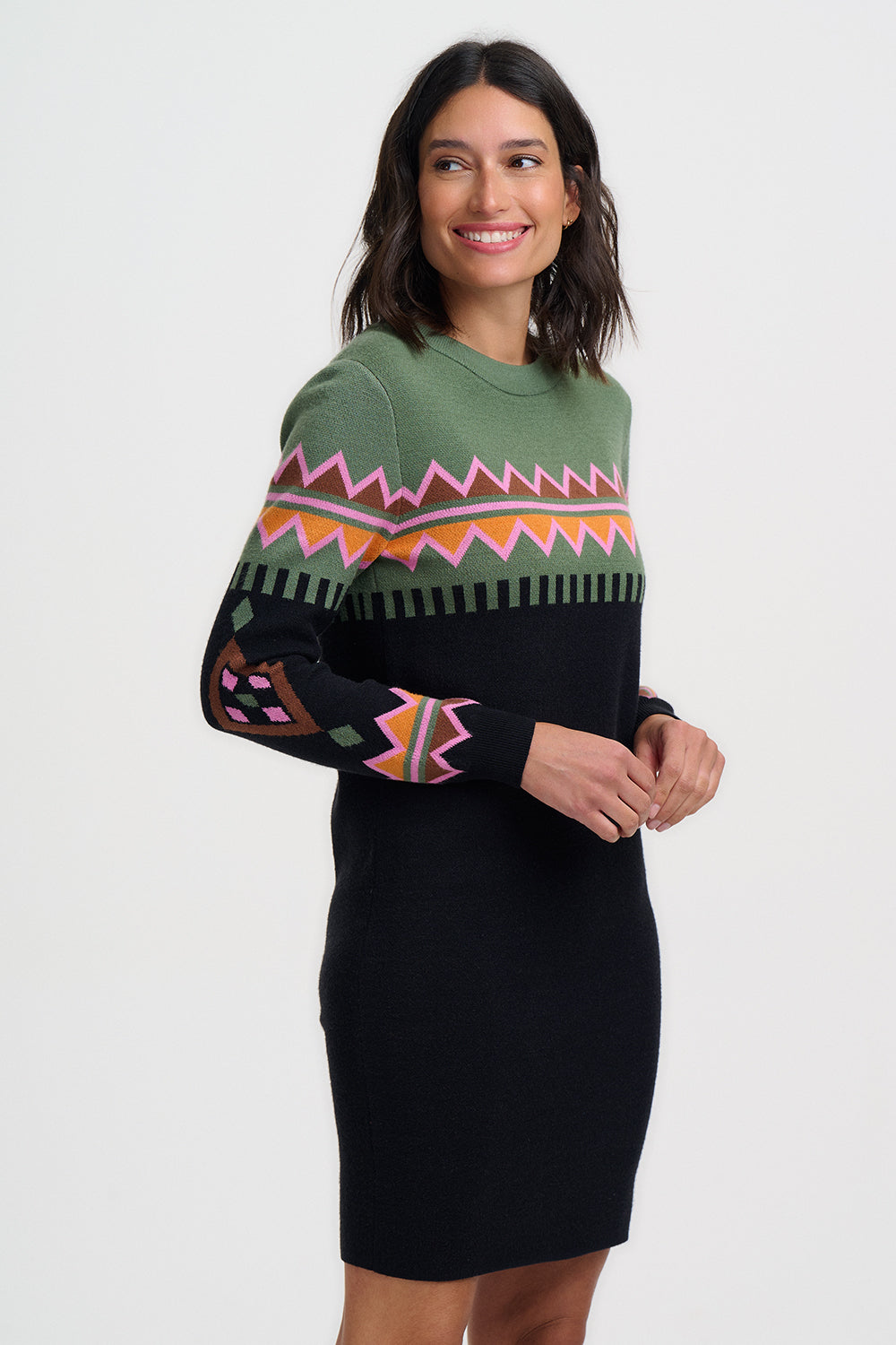 Woman wearing a green and black patterned sweater dress on a white background