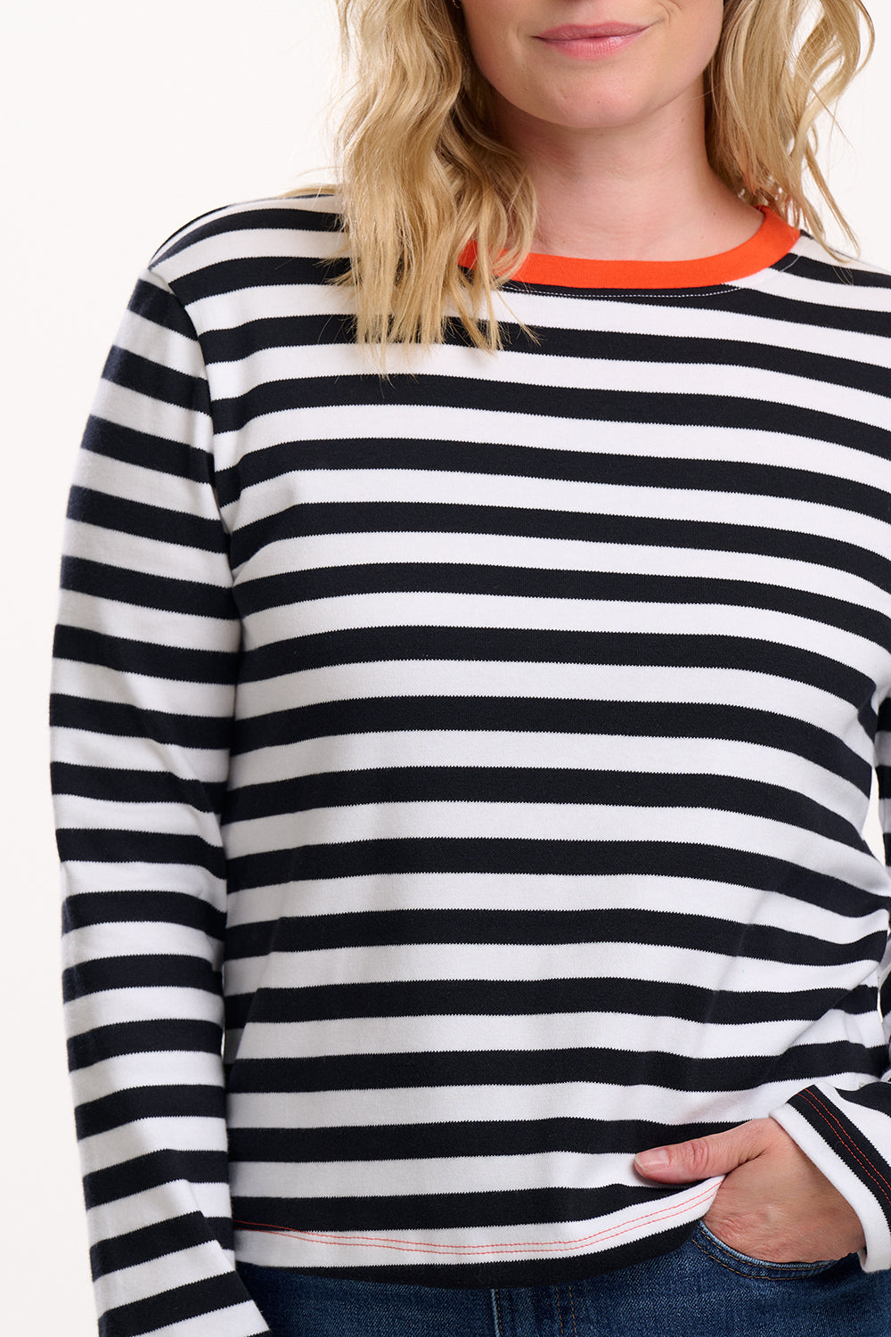 Sugarhill Brighton is wearing a black and white striped long-sleeve shirt with an orange collar.
