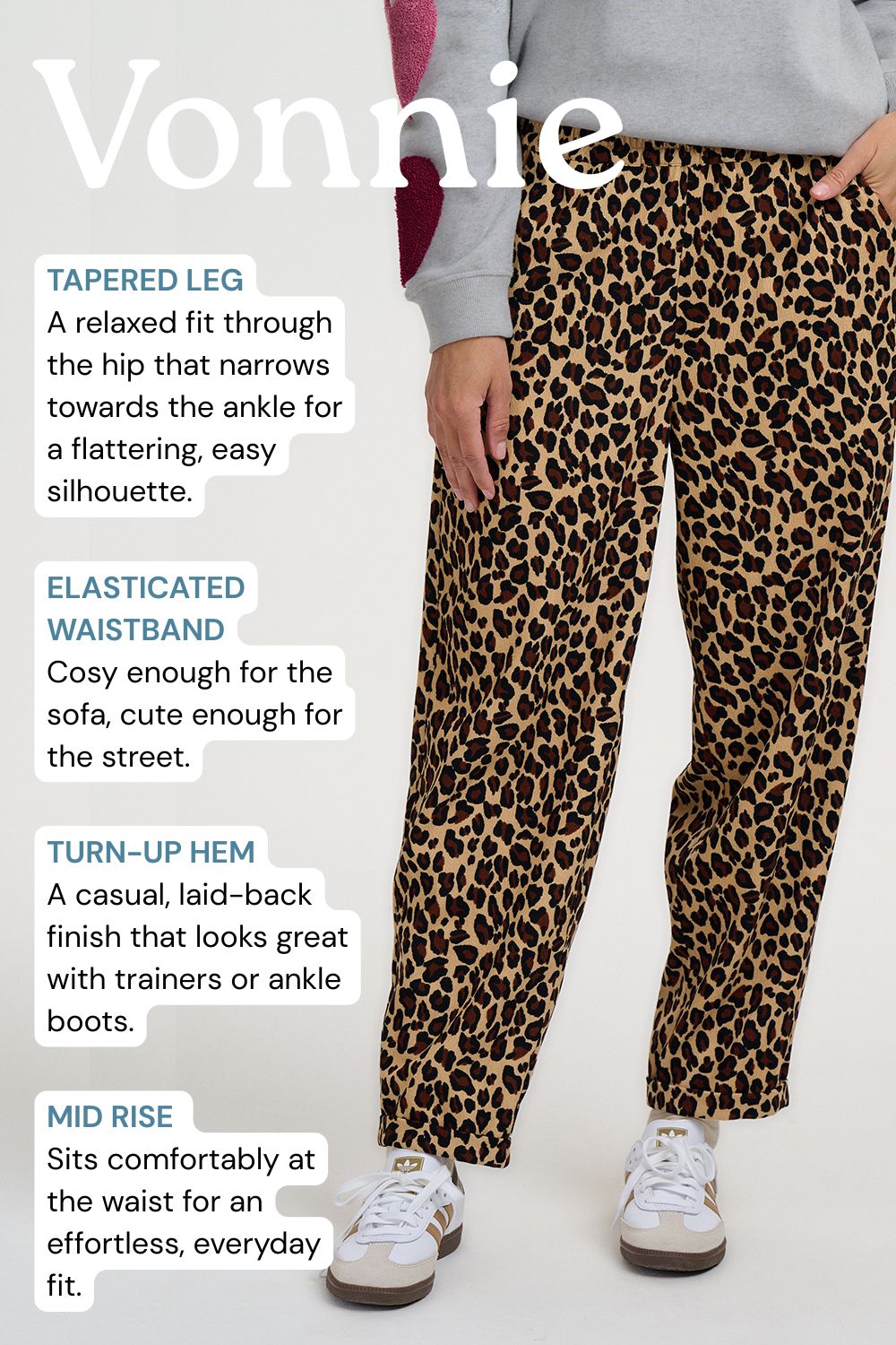 A person wearing leopard-print pants with a gray sweatshirt and white sneakers, shown from the waist down with text callouts describing the tapered leg, elastic waistband, turn-up hem, and mid-rise fit. The word 'Vonnie' appears at the top.